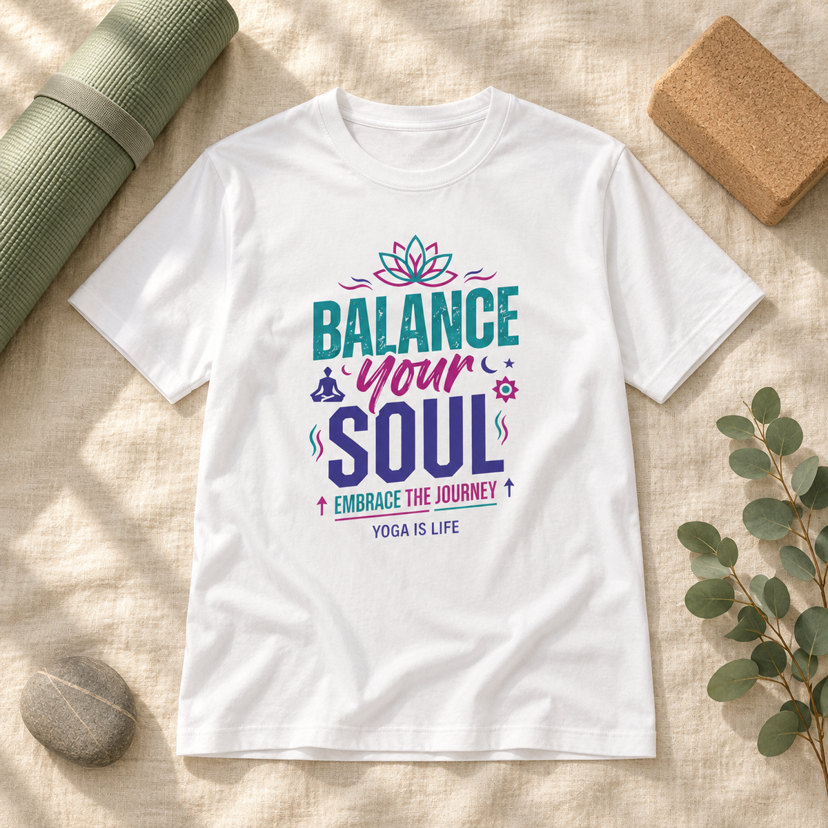 White Balance Your Soul T-shirt flatlay with yoga mat, cork block, eucalyptus and river stone